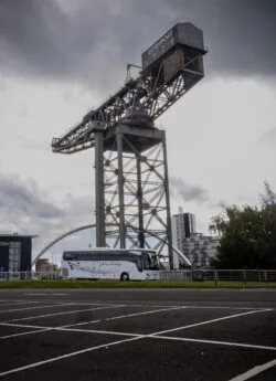 Hire Society Coach in front of crane and arch Glasgow
