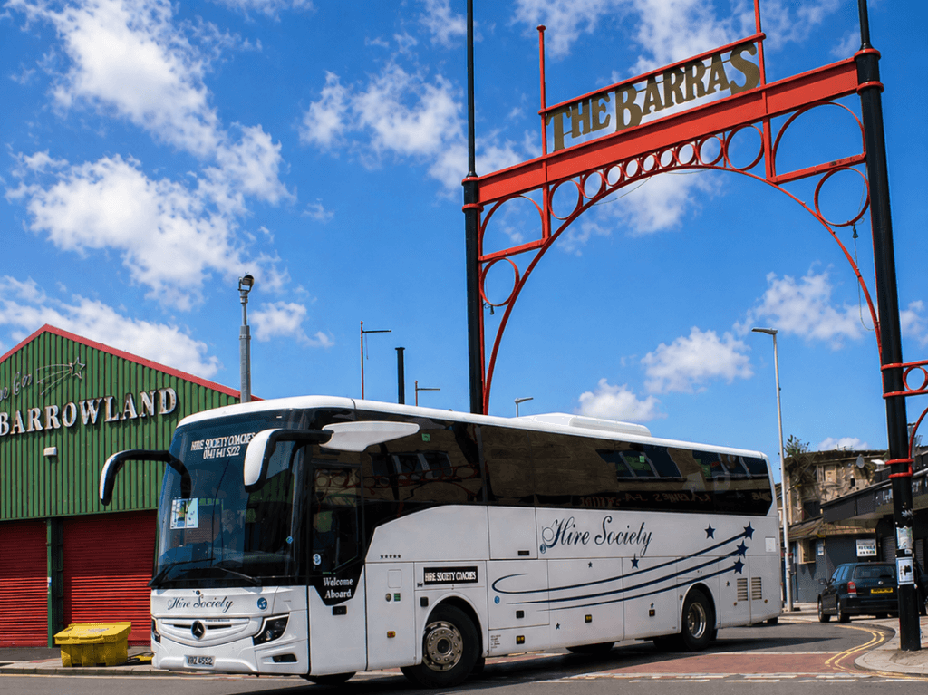 Hire Society Coach Exiting the Barras Market Glasgow, historic street market with vintage clothes, records, and collectibles