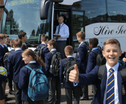 A school group boarding a coach with backpacks and sports kit. Coach hire for school trips and sports tours Scotland, safe group transport for pupils